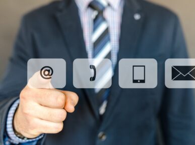 mężczyzna wskazuje palcem na ikony przedstawiające różne sposoby komunikacji. Obraz symbolizuje omnichannel